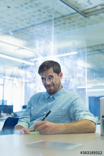 Portrait confident businessman taking notes in office