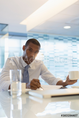 Portrait confident businessman with coffee working in office