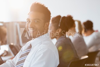 Portrait confident businessman with headset working in call center