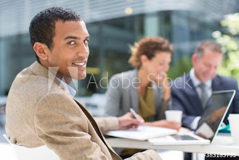 Portrait confident businessman working at table outdoors