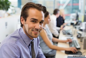 Portrait confident businessman working in open plan office