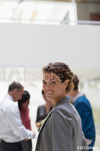 Portrait confident businesswoman in office with colleagues