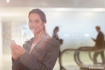 Portrait confident businesswoman using smart phone in office