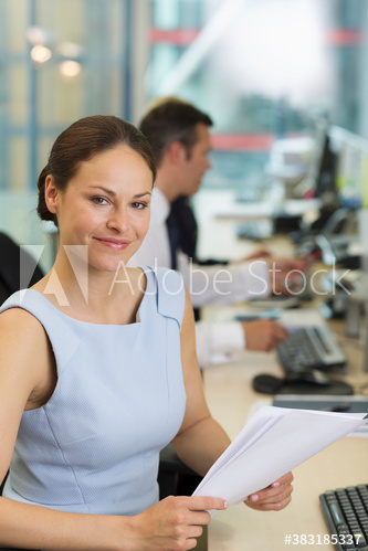 Portrait confident businesswoman with paperwork in office