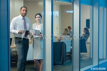 Portrait confident corporate business people in conference room window