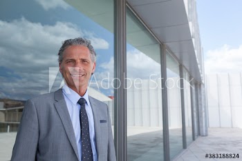 Portrait confident corporate businessman in suit on modern patio