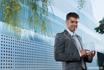 Portrait confident corporate businessman using smart phone outside