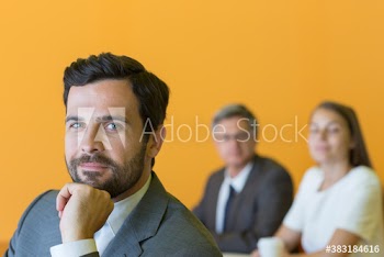 Portrait confident corporate businessman with colleagues in office