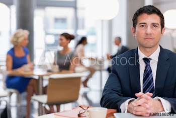 Portrait confident corporate businessman working in cafe