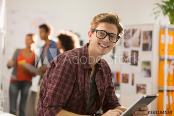 Portrait confident creative young businessman using digital tablet in office
