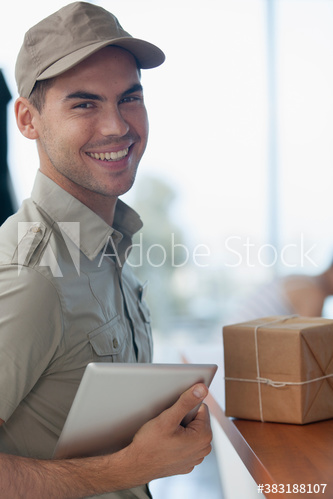 Portrait confident deliveryman with digital tablet and package