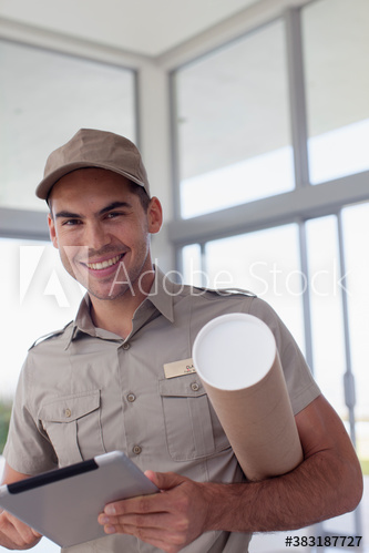 Portrait confident deliveryman with digital tablet and package tube