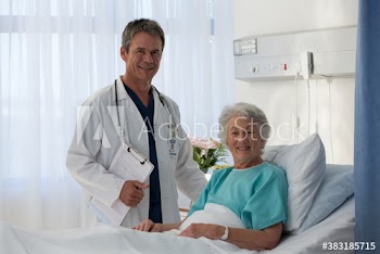 Portrait confident doctor checking on senior patient in hospital room