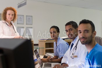 Portrait confident doctors and nurses at nurses station in hospital
