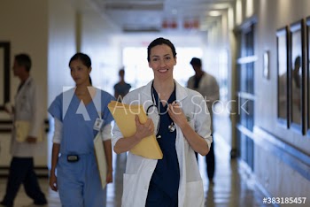Portrait confident female doctor making rounds in hospital corridor