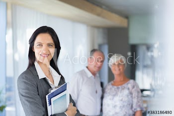 Portrait confident female financial advisor meeting with senior couple