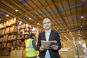 Portrait confident female manager in distribution warehouse