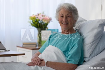 Portrait confident female senior patient in hospital bed