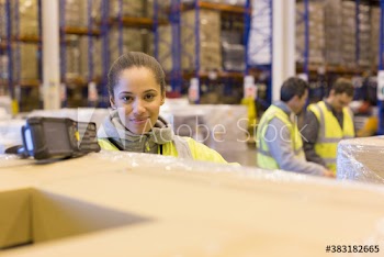 Portrait confident female worker scanning boxes in warehouse