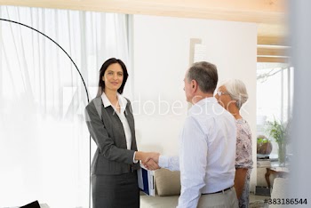 Portrait confident financial advisor shaking hands with senior couple