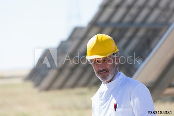 Portrait confident male engineer working on sunny solar farm