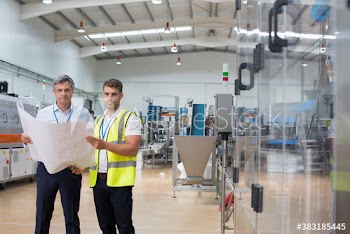 Portrait confident male engineers with blueprints in factory