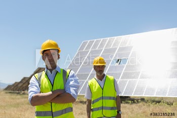 Portrait confident male engineers working on sunny solar farm