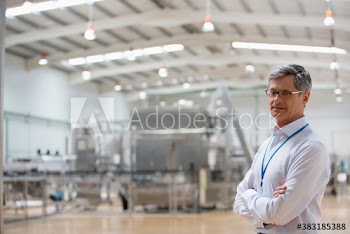 Portrait confident male manager supervising factory floor