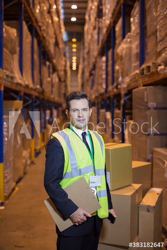 Portrait confident male manager working in distribution warehouse
