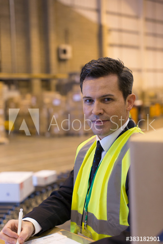 Portrait confident male manager working in distribution warehouse