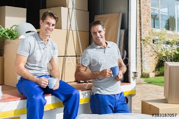 Portrait confident male movers enjoying coffee break at moving van