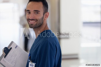 Portrait confident male nurse with clipboard in hospital