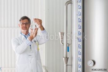 Portrait confident male scientist examining liquid in beaker