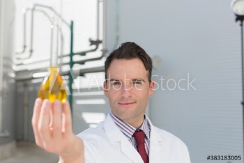 Portrait confident male scientist holding vial on dairy farm