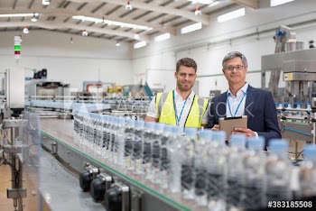 Portrait confident male worker and manager at water bottling plant