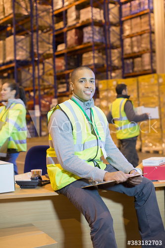 Portrait confident male worker at desk in distribution warehouse