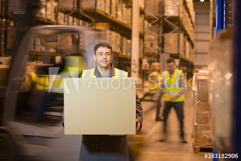 Portrait confident male worker carrying box in distribution warehouse