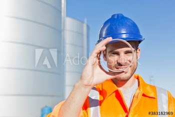 Portrait confident male worker looking through stainless steel tube