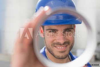 Portrait confident male worker looking through tube