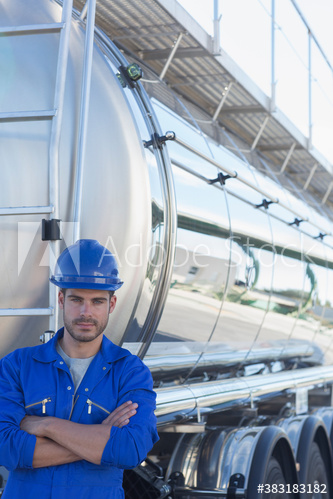 Portrait confident male worker standing at back of milk tanker