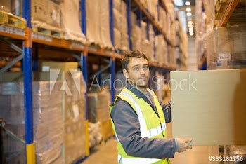 Portrait confident male worker with box in distribution warehouse