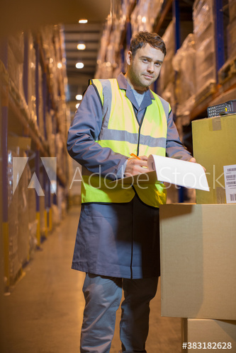 Portrait confident male worker with clipboard in distribution warehouse