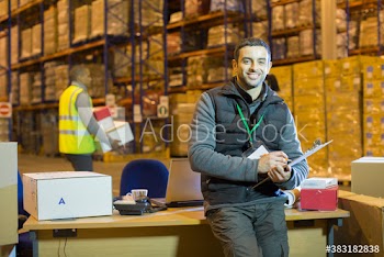 Portrait confident male worker with clipboard in distribution warehouse