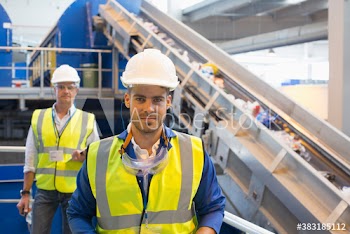 Portrait confident male workers in recycling plant