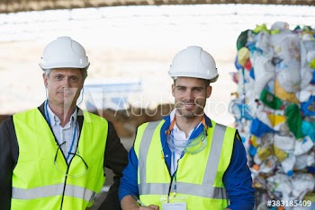 Portrait confident male workers in recycling plant