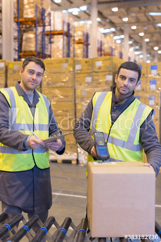 Portrait confident male workers scanning box in distribution warehouse