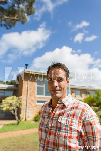 Portrait confident man outside sunny house
