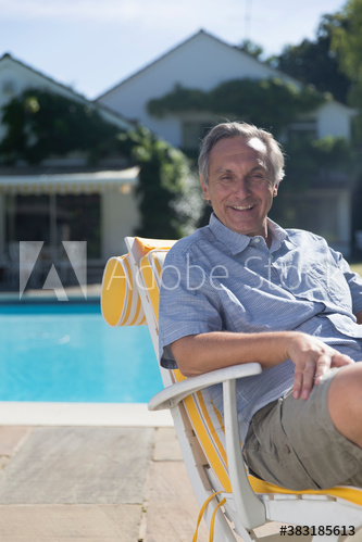 Portrait confident man relaxing at sunny poolside