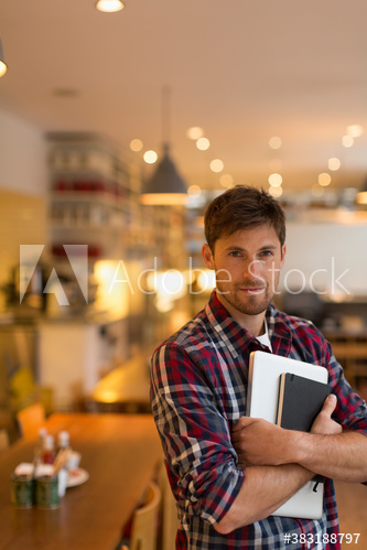 Portrait confident man with laptop in cafe