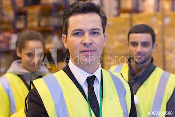 Portrait confident manager and workers in distribution warehouse